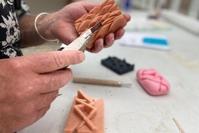 Homme sculptant un morceau de savon dans son atelier